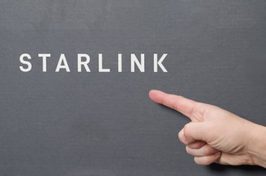 Ivano-Frankivsk, Ukrayna 2 Aralık 2023: Logolu Starlink anten kutusu, işaret parmağıyla Space X şirketinin logosunu gösteren adam, uydu iletişim anteni.