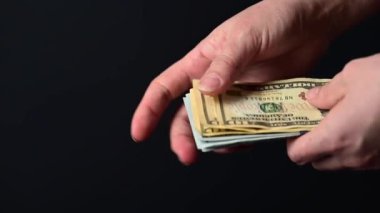 Yüz dolarlık banknotların dönüştürülmesi, iş adamlarının para sayması, kara arka planda para, dünya piyasası para birimi.