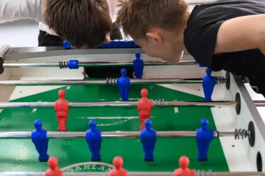 Oyun odasında aktif eğlence, çocuklar masa futbolu oynuyor, çocuklar için aktif oyun.