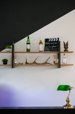 Barın yanındaki raflarda içki ve vazolar var. Bir berber dükkanında iç mekan elementleri.