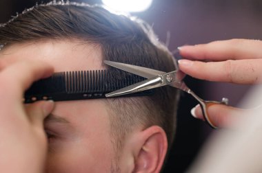 Saç kesimi yakın ve kafanın dış hatları makas ile hizalanır. Berber dükkanında kısa saç kesimi..