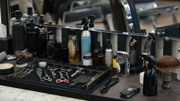 Men\'s hair and beard care products. Barbers tools for mens haircuts laid out on a table.