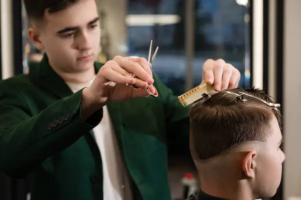 Haircut and alignment of the contour of the head with scissors. Short haircut in the barbershop.