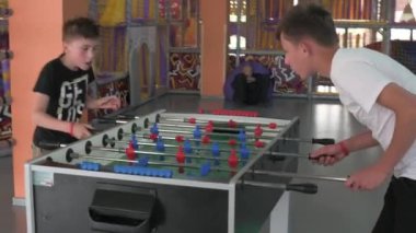 Oyun odasında iki çocuk futbol oynuyor, zihinsel ve aktif eğlence..