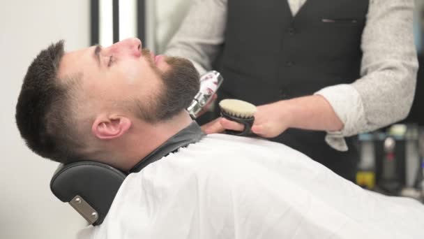 床屋は首をトリミングし ひげ付きの男4Kビデオを切っている間 コードレスのトリマーとひげを剃ります — ストック動画