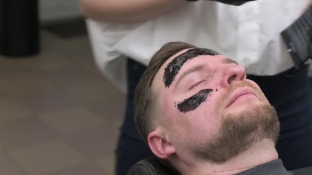 Barber Applies Black Moisturizing Mask Mans Face While Shaving Dermatologist — Stock Video