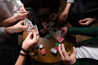 Pokerin çeşitli yakın çekim açılarından birinci şahıs gözlemi. Bir grup genç kız ve erkek poker oynuyor..