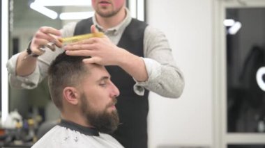 Saç kesimi ve kafa hatlarının makas ile hizalanması. Berber dükkanındaki 4K videosundaki kısa saç kesimi..