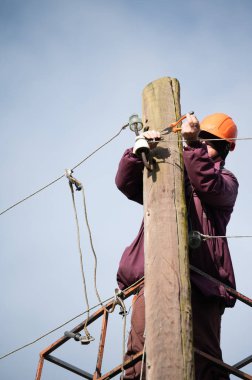 Erkek bir elektrik işçisi elektrik iletim hattını tamir ediyor, bir elektrikçi iş başında..