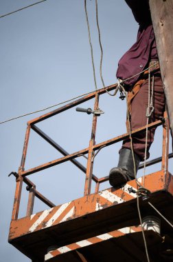 Bir elektrik direğinin bakım ve onarımı için hidrolik kova asansörü kullanılıyor. Bir elektrikçi, bakım kamyonu sahasında bir sokak lambasını tamir ediyor.