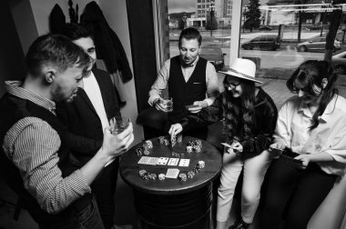 Pokerin çeşitli yakın çekim açılarından birinci şahıs gözlemi. Bir grup genç kız ve erkek poker oynuyor..