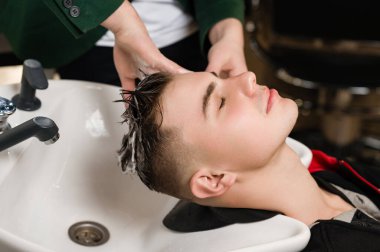 Berber, erkek müşterinin kafasını lavaboda yıkıyor..