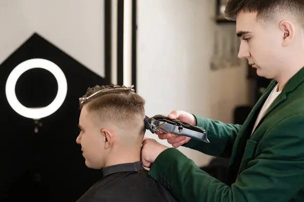 stock image Haircut and alignment of the head contour with a hair clipper and trimmer. Short haircut in the barbershop.