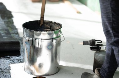 Evde gaz lambası kullanarak reçineyi kovada ısıtma yöntemi, zemini reçineyle su geçirmez hale getirmek..