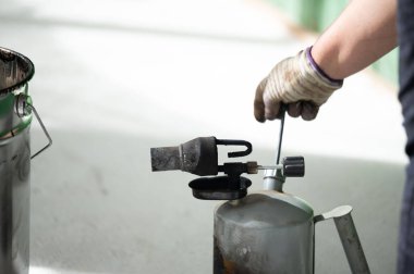 Evde gaz lambası kullanarak reçineyi kovada ısıtma yöntemi, zemini reçineyle su geçirmez hale getirmek..