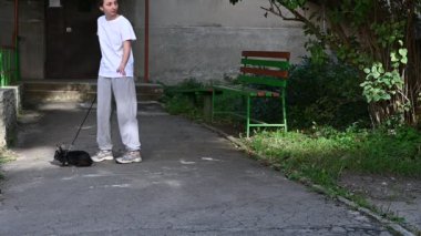 Bir kız sokakta evcil tavşanını tasmasıyla gezdirir, bir evcil hayvan ve onunla yürür..