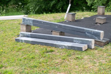 Bir taraça kurmak için malzemeler: tesisat alanına kirişler ve tahtalar, bahçeye ahşap bir çardak kurulumu.