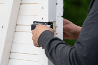 Çardakta bir oda için küçük bir kapı kilidi takmak, marangozluk işi..