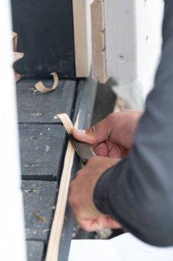 Bir adam, bir marangoz aleti kullanır, bir değirmen kesicisi, kapının altından bir eşik kesmek için, bir balkon inşaatında dakikalar.