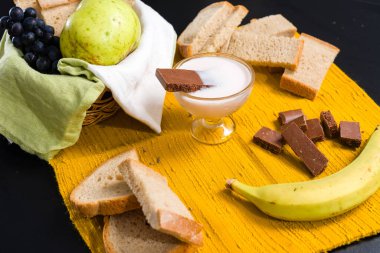 Meyve, ekmek, yoğurt ve çikolatayla yayılmış kahvaltı..