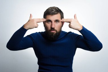 Sakallı bir adam şakağına silah doğrultulmuş parmaklarıyla sinsi sinsi hareketler yapar. Hayal kırıklığı ya da intihara meyilli düşüncelere işaret eder..