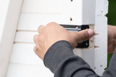 Çardakta bir oda için küçük bir kapı kilidi takmak, marangozluk işi..