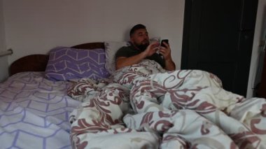 Bir adam uyanır ve telefonundan haberleri ve postaları kontrol eder. Sabah telefonla başlar..