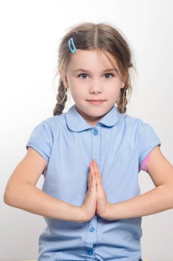 Açık mavi gömlek giymiş, at kuyruklu, dingin genç bir kızın portresi. Elleri birbirine bastırılmış, dua ya da meditasyon olduğunu gösteriyor. Arkaplan düz beyaz.