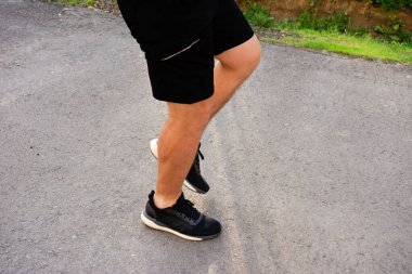 Atletik giysili biri yıpranmış bir binanın yanındaki eski taş basamaklara tırmanır. Olay yeri fiziksel aktivite ve şehir ortamını gösteriyor..