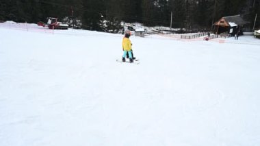 İki snowboardcu el değmemiş bir kar yamacında. Arkasında karla kaplı ağaçlar olan bir kış harikalar diyarı. Kış sporları için mükemmel.