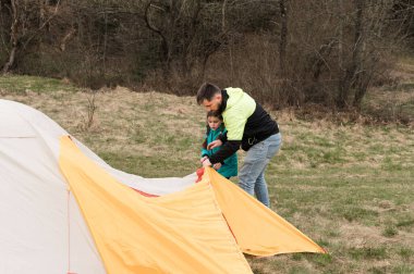 Bir baba ve çocuk, doğa ile çevrili huzurlu bir ortamda canlı bir çadır kurmak için yan yana çalışarak bir kamp macerasında sevgi dolu anlar yaratırlar..