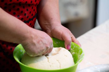 Parlak bir mutfakta eller özenle çalışırken hamur yoğurmak bir sanat haline geliyor. Hava taze pişmiş ekmek vaadiyle dolu. Hoş bir ortam yaratıyor..