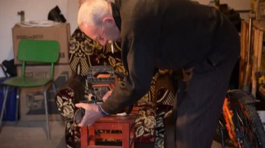 Dedem elektrikli testereyi biler. Odaklanmış bir birey, rahat bir atmosferle çevrili araçlar ve çeşitli materyallerle ilgili bir proje üzerinde ustalıkla çalışıyor..