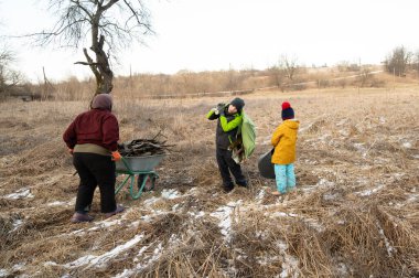 Cesur ruhlar serin bir ortamda birlikte çalışarak sıcak bir geceye hazırlanmak için yakacak odun toplarlar. Takım çalışmaları çorak ama güzel arazide parlıyor..