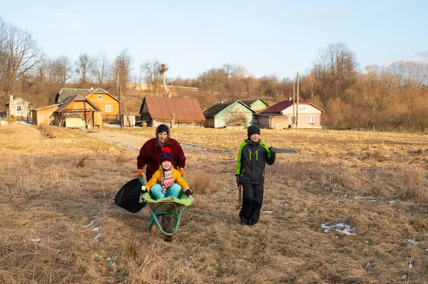 Güneşli bir kış gününde, bir aile açık havada keyifle vakit geçirir. Çocuklar neşeyle el arabasıyla gezerken ebeveynler çayırlık arazide etrafı kır evleriyle çevrili bir şekilde gezerler..