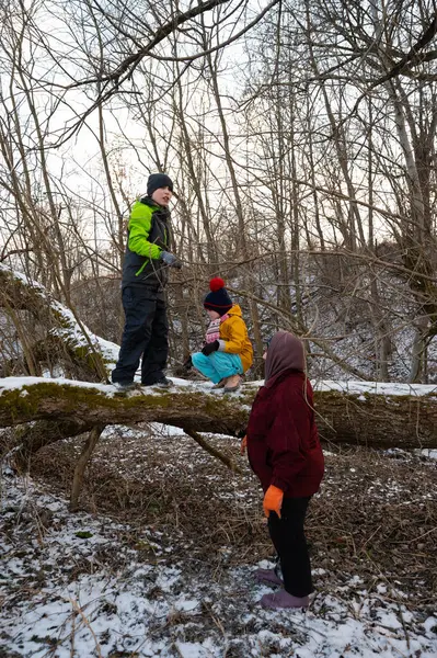 Çocuklar kış kıyafetleri içinde dışarıda toplanıyor, kar kaplı bir ormanın güzelliğinin tadını çıkarırken, soğuk bir dere kenarında, gün geceye dönerken neşeli anılar yaratıyorlar..