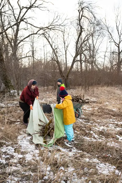 Soğuk bir kış öğleden sonra, bir grup karlı bir tarlada yakacak odun toplamak için toplanır, çıplak ağaçların arasında ve işbirliği ruhuyla birlikte çalışırlar..
