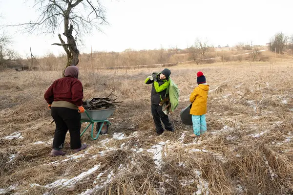 Cesur ruhlar serin bir ortamda birlikte çalışarak sıcak bir geceye hazırlanmak için yakacak odun toplarlar. Takım çalışmaları çorak ama güzel arazide parlıyor..