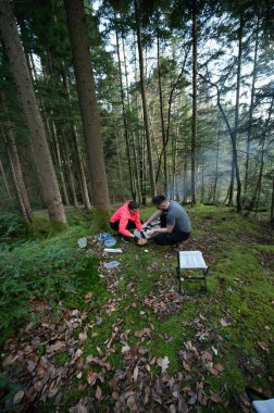 Huzurlu bir orman açıklığında, bir çift küçük bir sobanın etrafında toplanır, bir yemek hazırlar ve yemyeşil ve yumuşak güneş ışığı altında birbirlerinin arkadaşlığının tadını çıkarırlar..