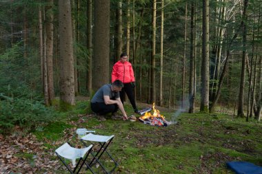 İki arkadaş sakin bir ormanda sakin bir öğleden sonra geçirir. Etrafı görkemli ağaçlarla çevrili, çatırdayan bir ateşin üzerinde yemek pişirir. Doğanın sakinleştirici seslerinin tadını çıkarırlar..
