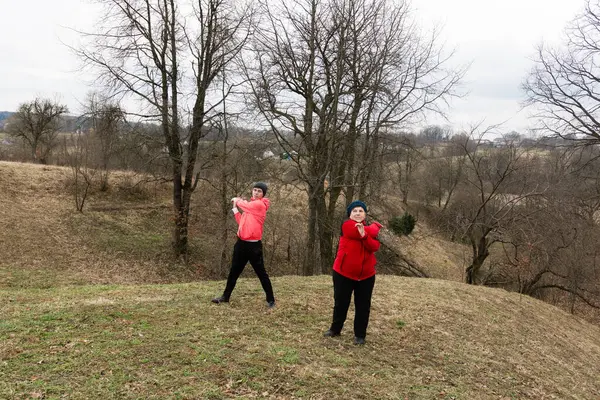 Barışçıl bir ortamda, iki kişi golf sopalarını coşkuyla sallar, kışın serin havasından ve birbirlerinin arkadaşlığından zevk alırlar..