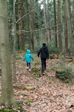 Sonbahar yapraklarıyla süslenmiş sakin bir orman yoluna iki kişi giriyor. Canlı mavi ceketli bir çocuk ve koyu renk elbiseli bir yetişkin. Doğada kalıcı anılar yaratıyor..