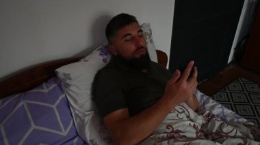 Bir adam uyanır ve telefonundan haberleri ve postaları kontrol eder. Sabah telefonla başlar..