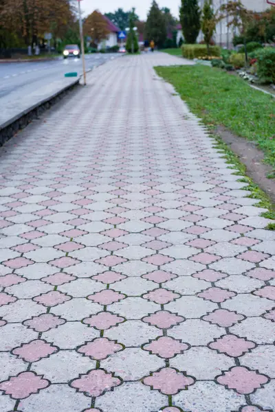 Karmaşık tasarımlarla süslenmiş büyüleyici kaldırım, huzurlu bir mahallede yemyeşil çimenler ve huzurlu bir yol kenarı ile çevrili akşam yürüyüşlerini davet ediyor..