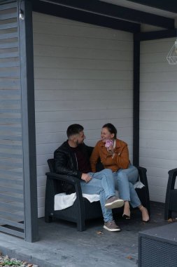 Birkaçı kahkahaları ve sıcaklığı paylaşırken aynı zamanda açık havada şık bir salonda dondurmanın tadını çıkarıyor, yapraklar düşerken rahat kıyafetlere bürünmüş..