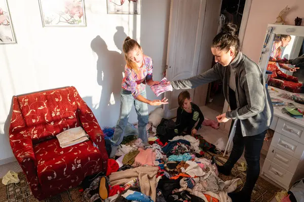 Canlı bir öğleden sonra, üç kişi neşeyle etrafı kahkaha ve birliktelikle doldurarak, kaotik kıyafet çeşitliliğine ayırırken,.