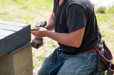 Tahta kirişleri delen bir adam, tahtayla çalışır..
