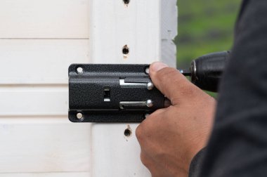 Çardakta bir oda için küçük bir kapı kilidi takmak, marangozluk işi..