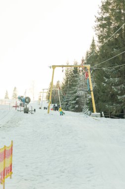 Heyecan arayanlar karla kaplı yamaçları fethederken canlı kayak asansörleri parlak bir gökyüzünün altında çalışır. Uzun çam ağaçları çarpıcı kış manzarasını çerçeveleyip maceraya davet ediyor..