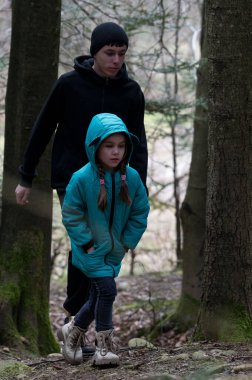 İki kardeş, doğanın sırlarını keşfetmek için öğleden sonra keşfe çıkan yüksek ağaçlarla çevrili sessiz bir ormanda dolaşıyorlar..